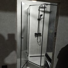 Угловая душевая кабина из прозрачного стекла с черной фурнитурой